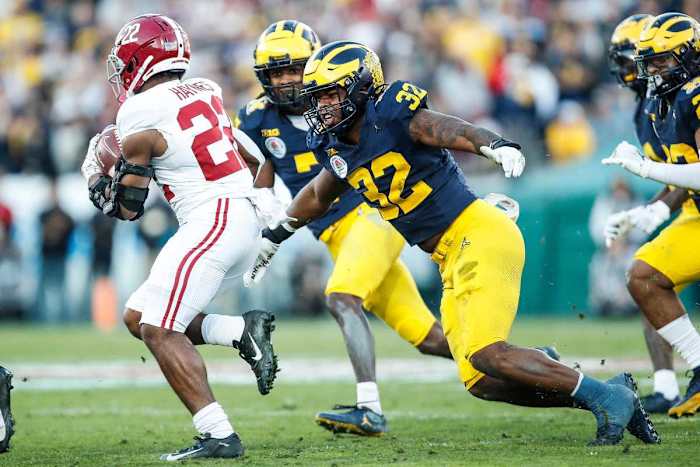 Michigan defensive end Jaylen Harrell (32) looks to tackle Alabama running back Justice Haynes.